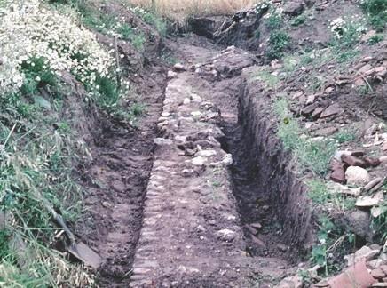 Excavation trench to reveal the villa's flint foundation walls.