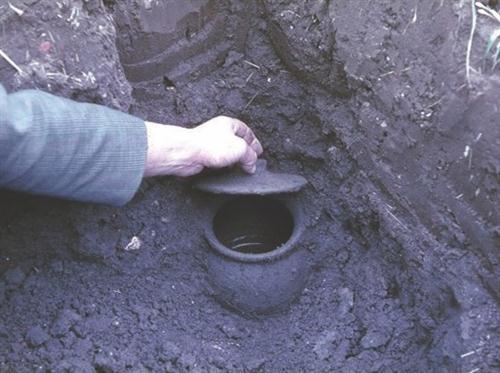 Unearthing one of the complete storage pots beneath the kitchen floor.